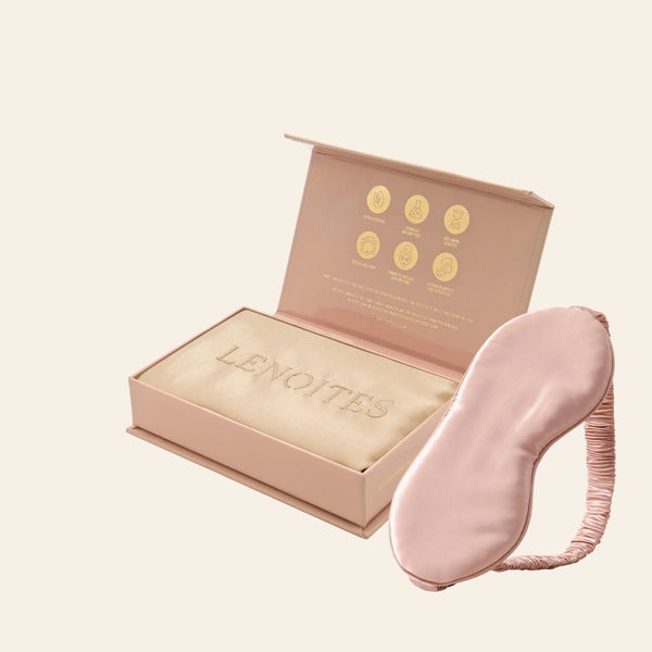 Pillowcase and Sleep Mask in Mulberry Silk by Lenoites featuring a pink silk sleep mask and a beige mulberry silk pillowcase presented in an open blush pink box against a soft light background.