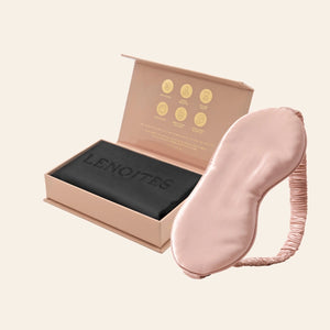 Pillowcase and Sleep Mask in Mulberry Silk by Lenoites featuring a pink silk sleep mask and a black mulberry silk pillowcase presented in an open blush pink box against a soft light background.