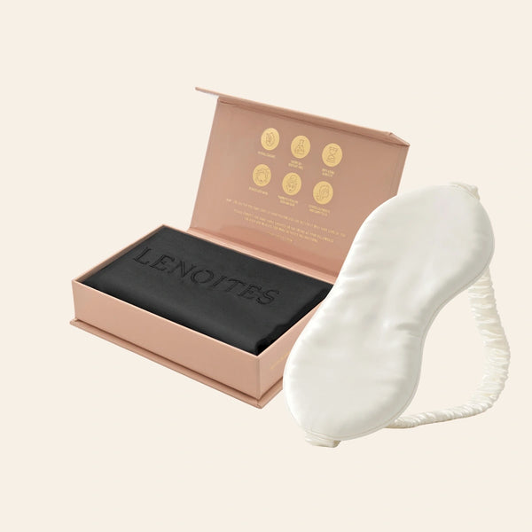 Pillowcase and Sleep Mask in Mulberry Silk by Lenoites featuring a white silk sleep mask and a black mulberry silk pillowcase presented in an open blush pink box against a soft light background.