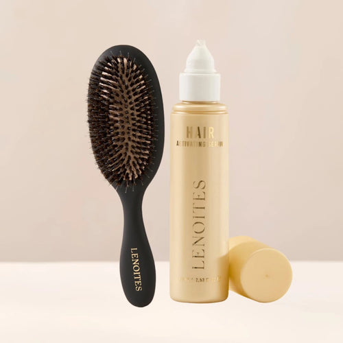 The Hair Growth Duo by Lenoites featuring a black hairbrush and the Hair Growth Serum in a transparent bottle with a golden tone, styled against a soft light beige background.
