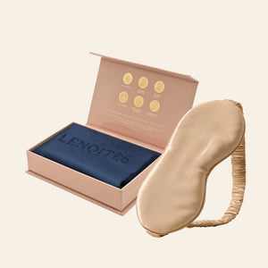 Pillowcase and Sleep Mask in Mulberry Silk by Lenoites featuring a beige silk sleep mask and a blue mulberry silk pillowcase presented in an open blush pink box against a soft light background.