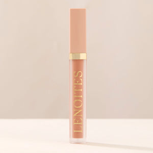Tinted Lip Oil in Classy by Lenoites, featuring a sleek tube with a pink cap and clear body, showcasing the soft pink tint, displayed against a soft beige background.